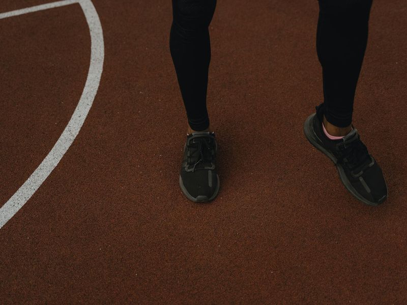 Close up of sports shoes on a running track surface.